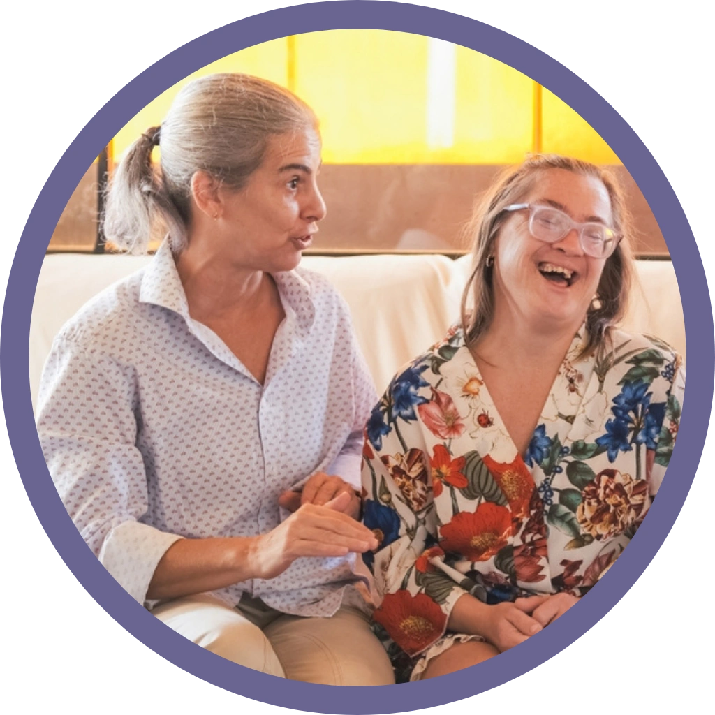 caretaker with a down syndrome women sitting on sofa